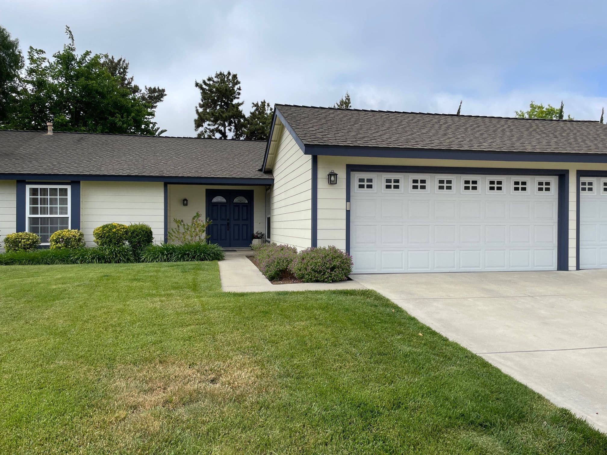 Single-story suburban house with garage, manicured lawn, and inviting entrance.